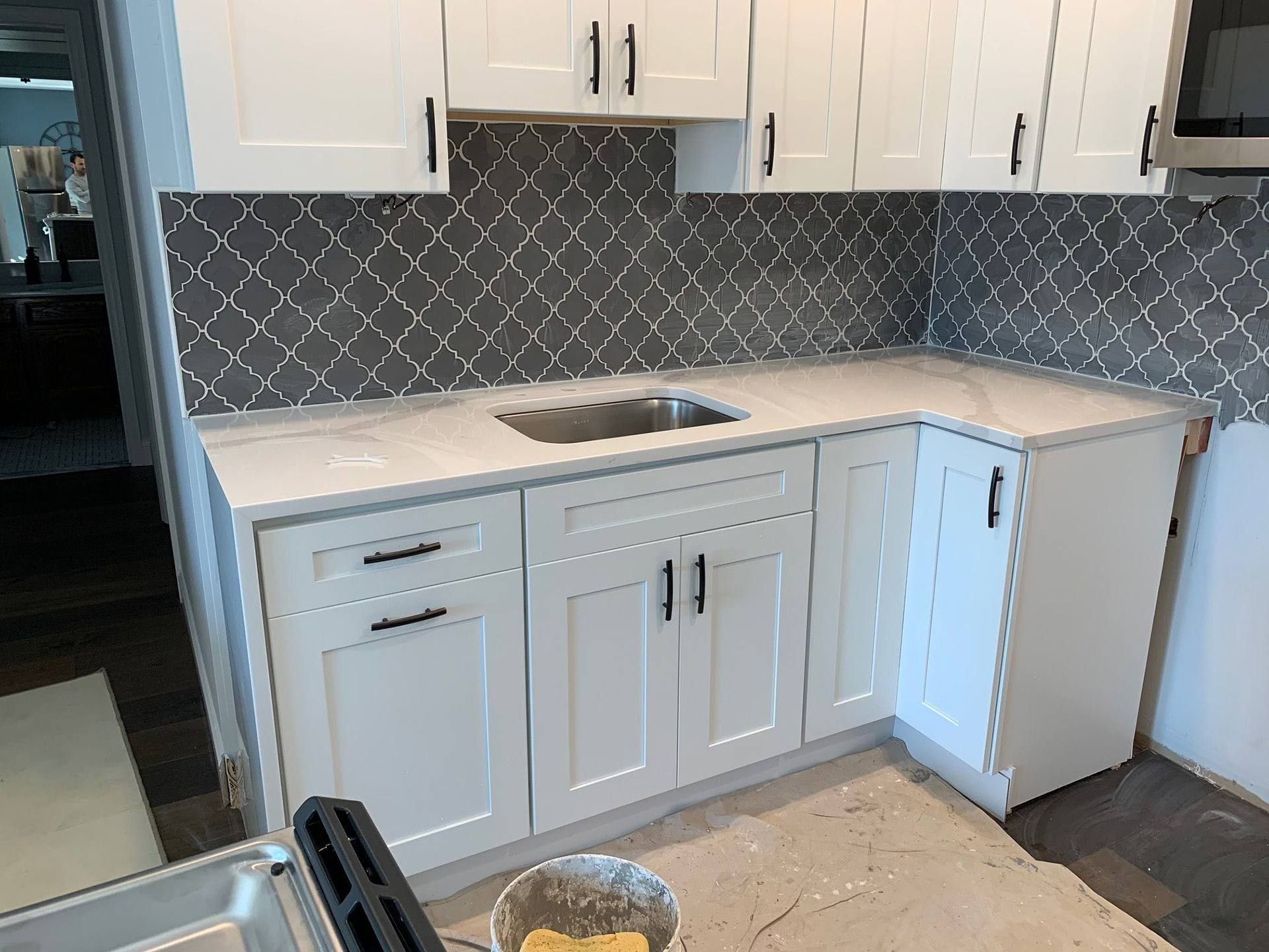 White kitchen cabinets with a patterned backsplash