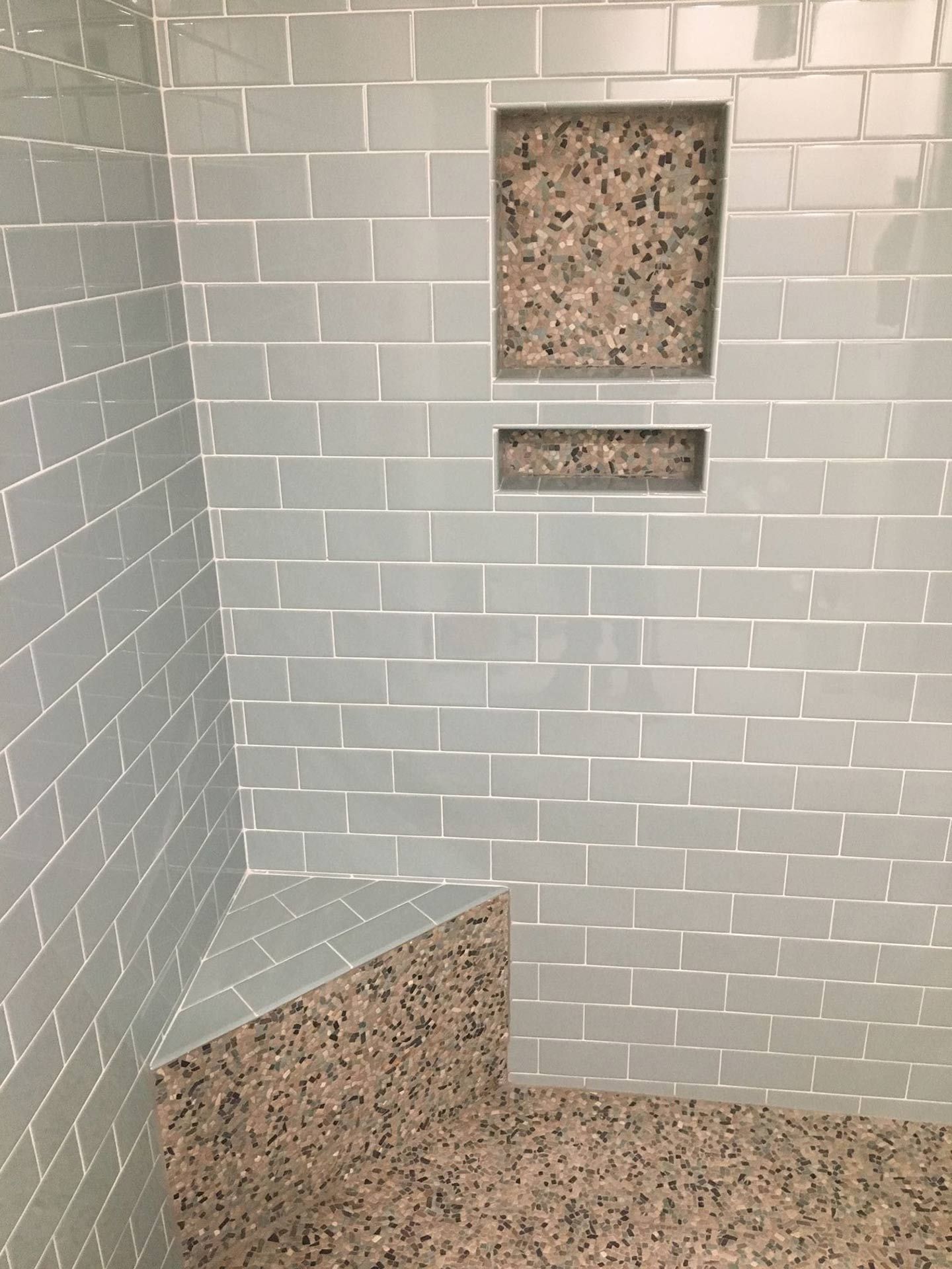 Bathroom tile wall with built-in shelves