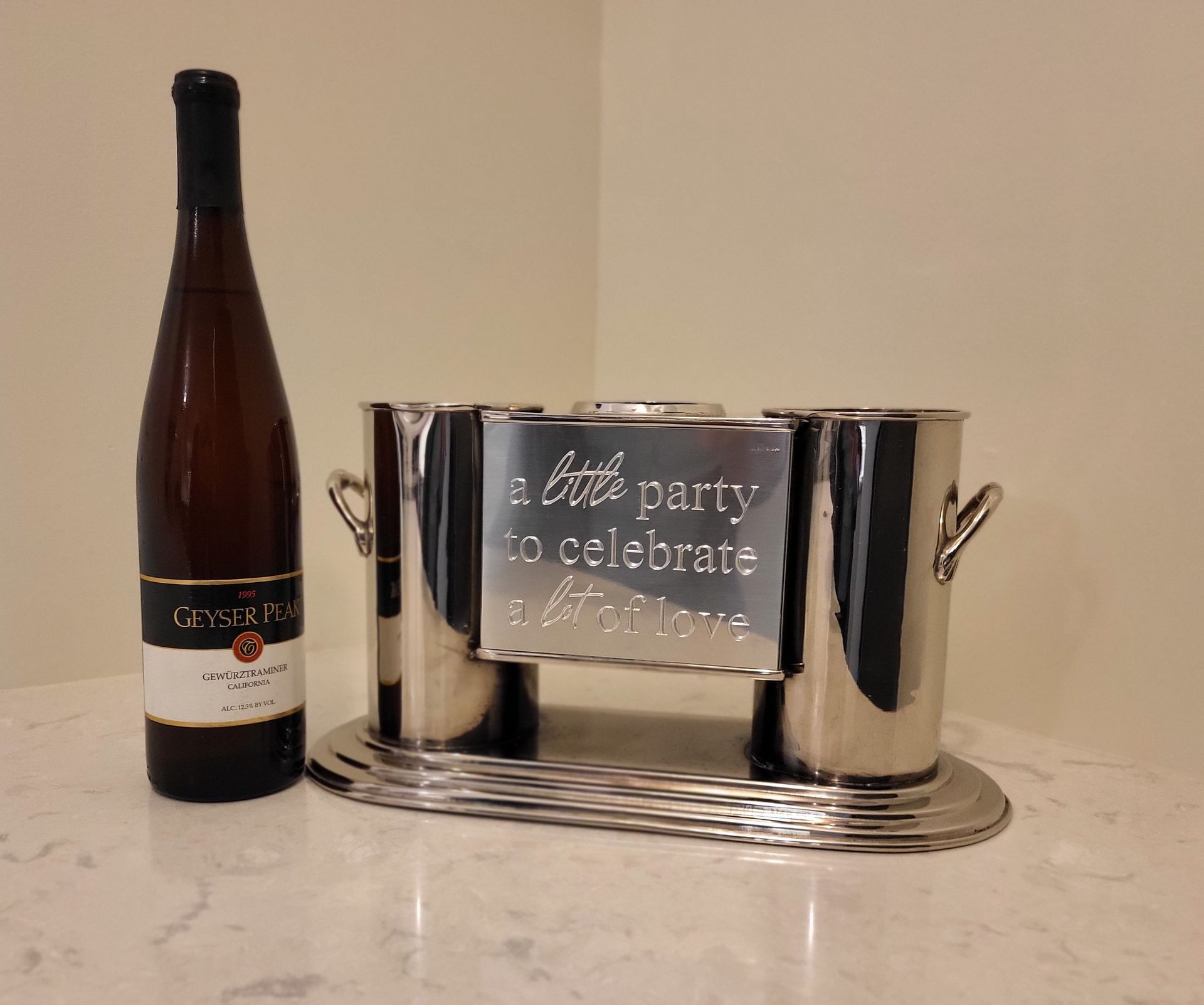 A silver double wine cooler featuring the engraved text 