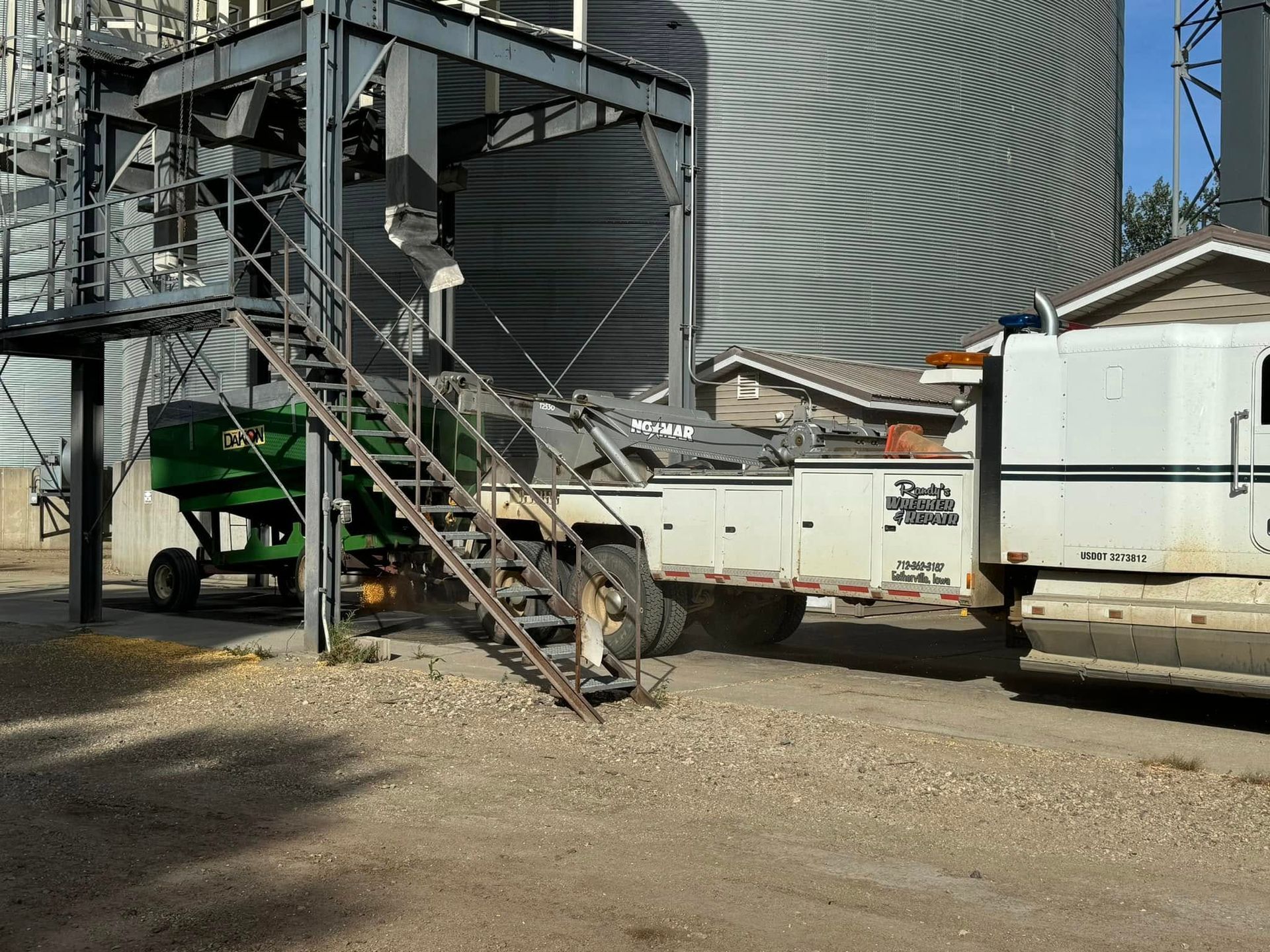 Grain elevator complex with truck and trailer, outdoor setting.