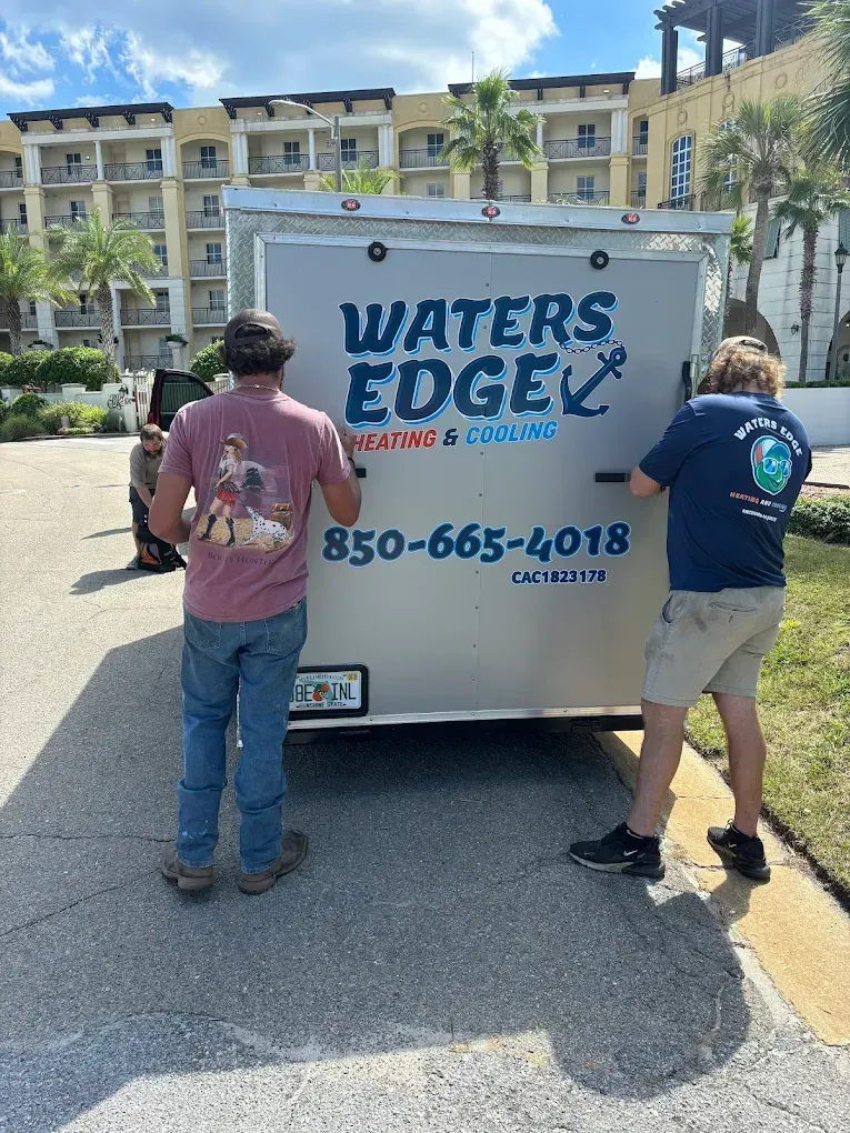 Two people pushing a trailer labeled