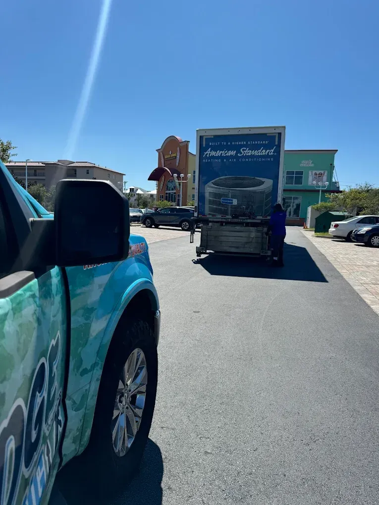 Blue truck beside a box truck with the brand 
