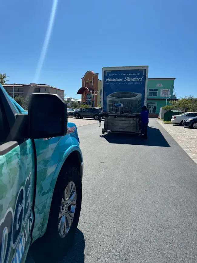 Blue truck beside a box truck with the brand