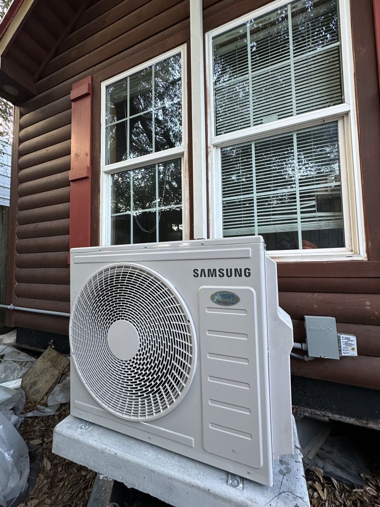 Samsung air conditioning unit outside a brown log cabin.