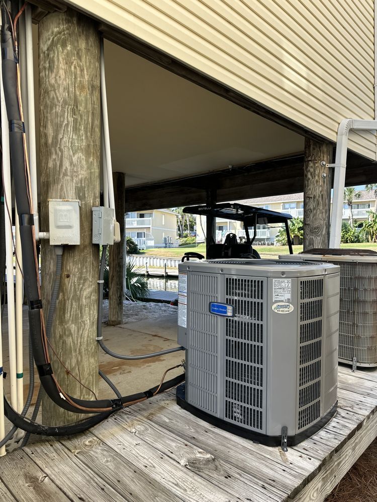 Air conditioning unit on a wooden deck near a golf cart under a building.
