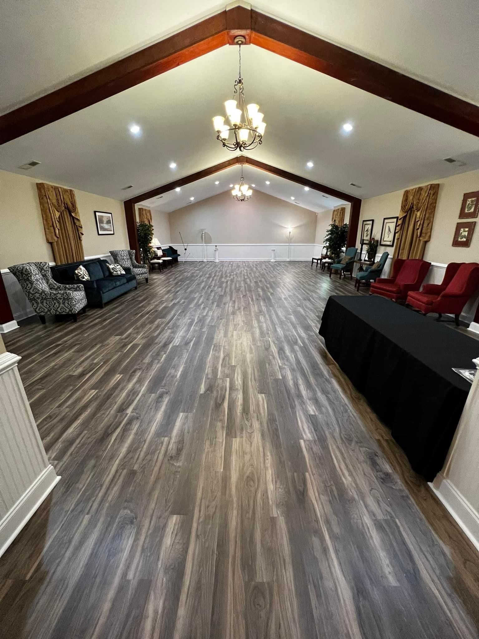 A large room with wooden floors and a vaulted ceiling.