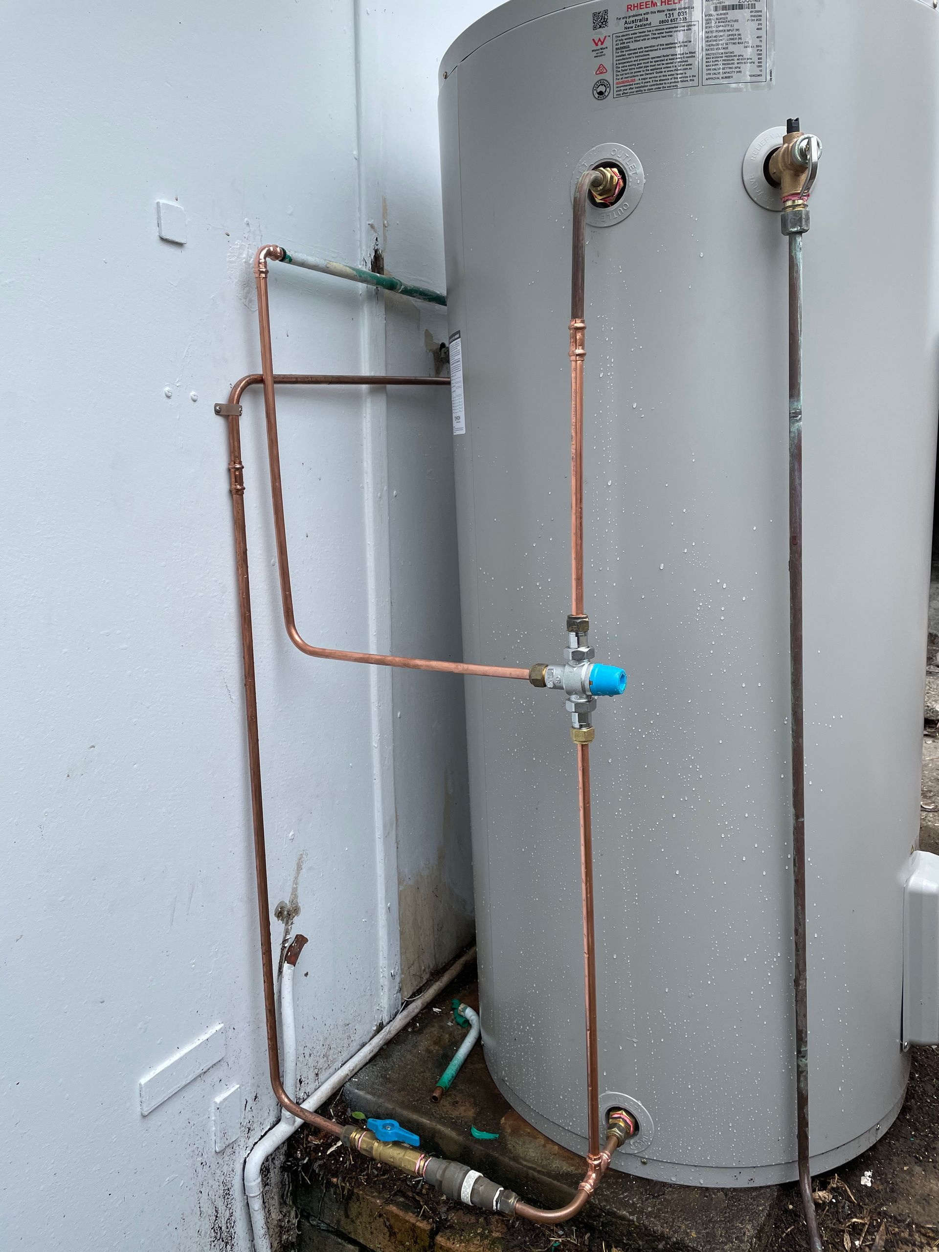 A Water Heater With Copper Pipes on a White Wall — Start 2 Finish Plumbing in Caringbah, NSW