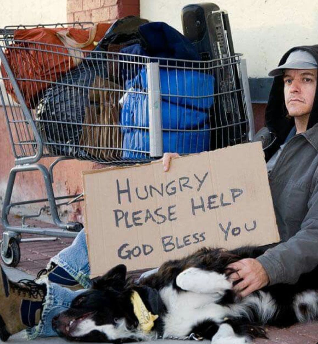 Person in blue jacket shakes hands with someone wearing blue sweater, holding a metal cup outside.