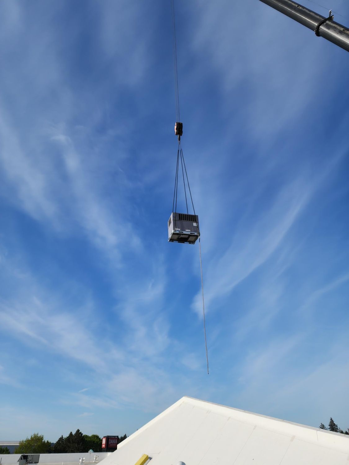 A truck is being lifted by a crane in the sky