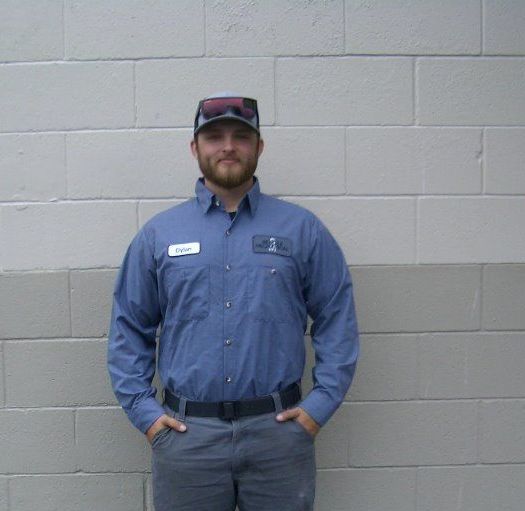 A man standing in front of a brick wall with his hands in his pockets