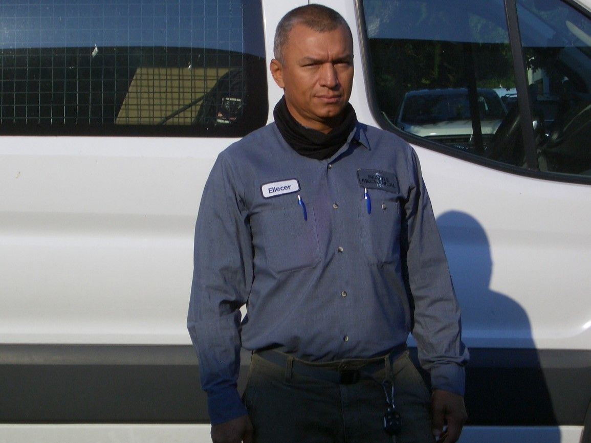A man is standing in front of a white van