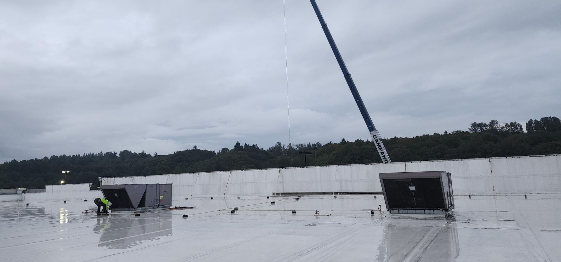 A large white roof with a crane on top of it.