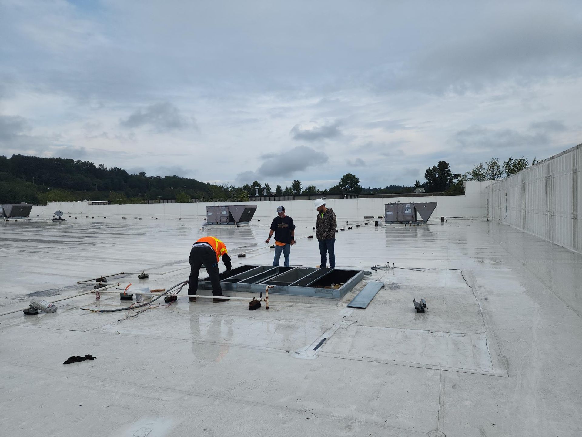 Three men are working on the roof of a building.
