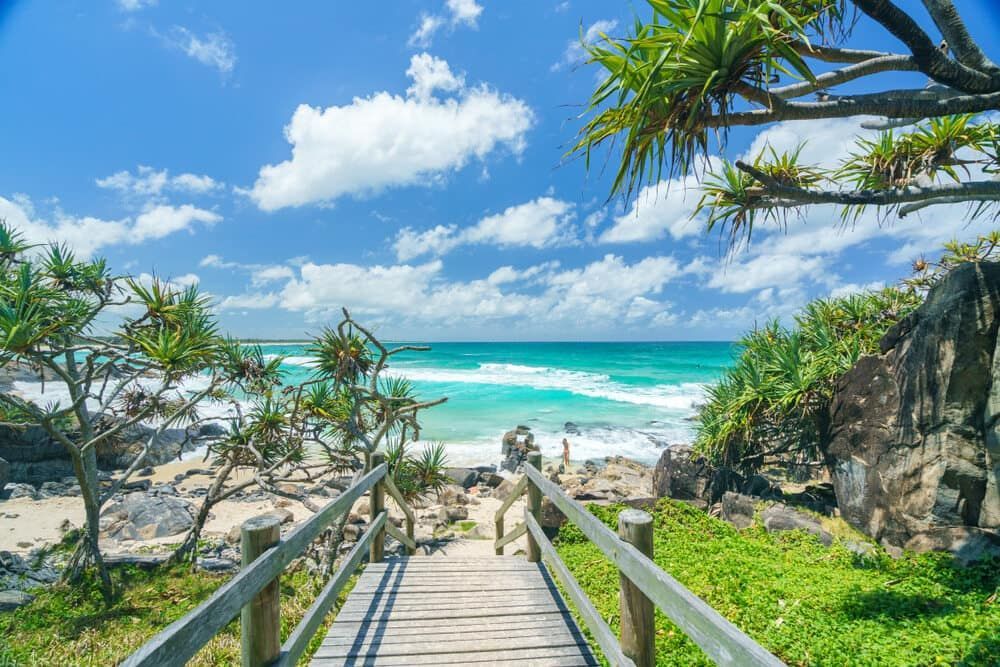 A Wooden Walkway Leading To The Ocean On A Sunny Day — Greg Pollard Building In Cabarita, NSW