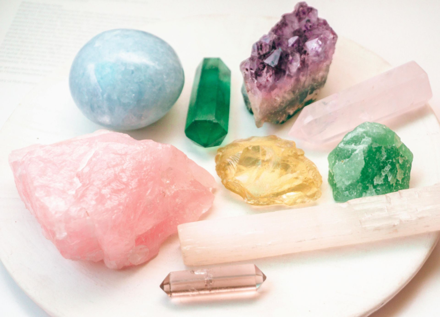 Assorted colorful crystals and gemstones arranged on a white plate