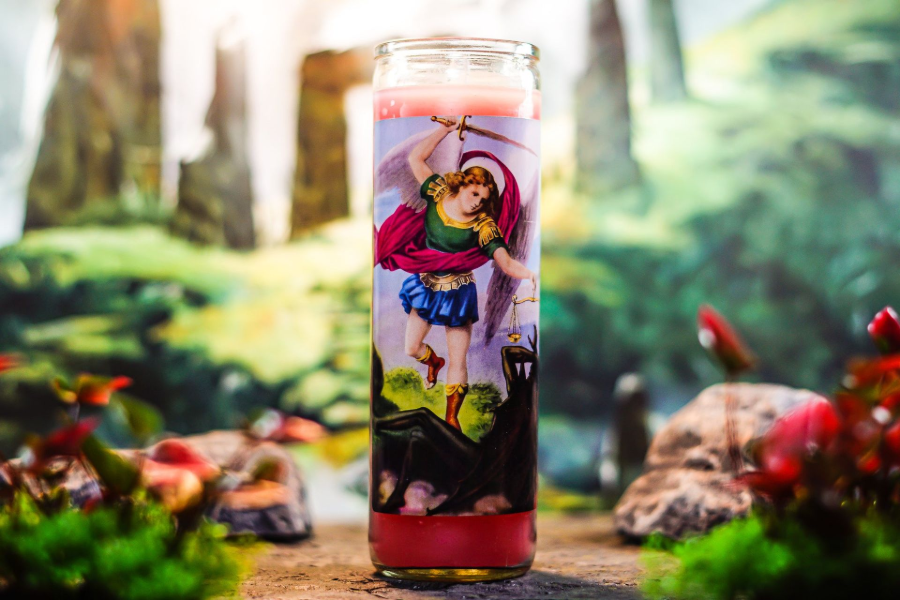 Glowing glass candle with colorful Supergirl illustration on a forest path backdrop