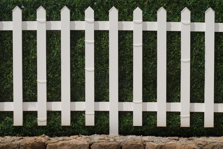 a white spike vinyl fence