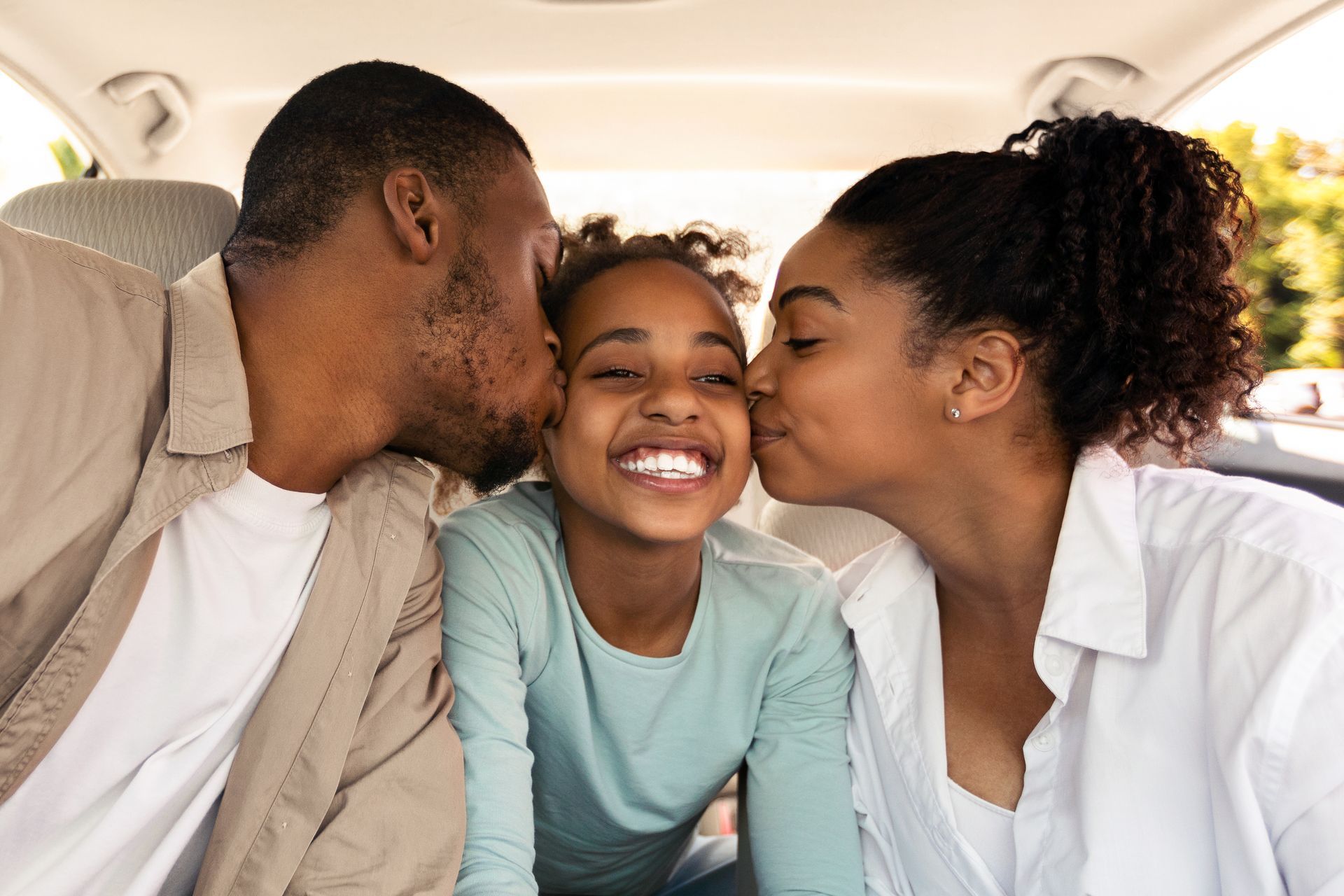 Woman and boy packing luggage together, smiling. Yellow top, white shirt, indoor setting.