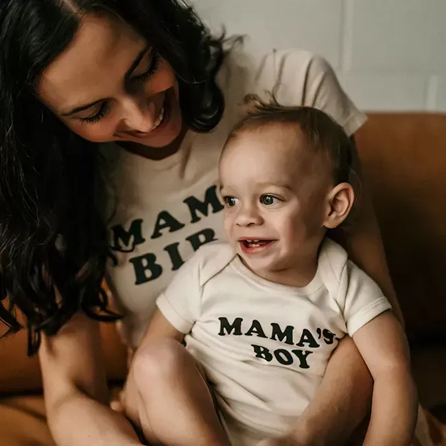 A smiling woman and baby boy wearing matching
