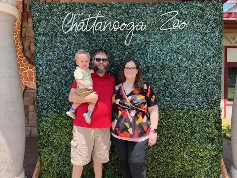 Family poses in front of a green wall with 