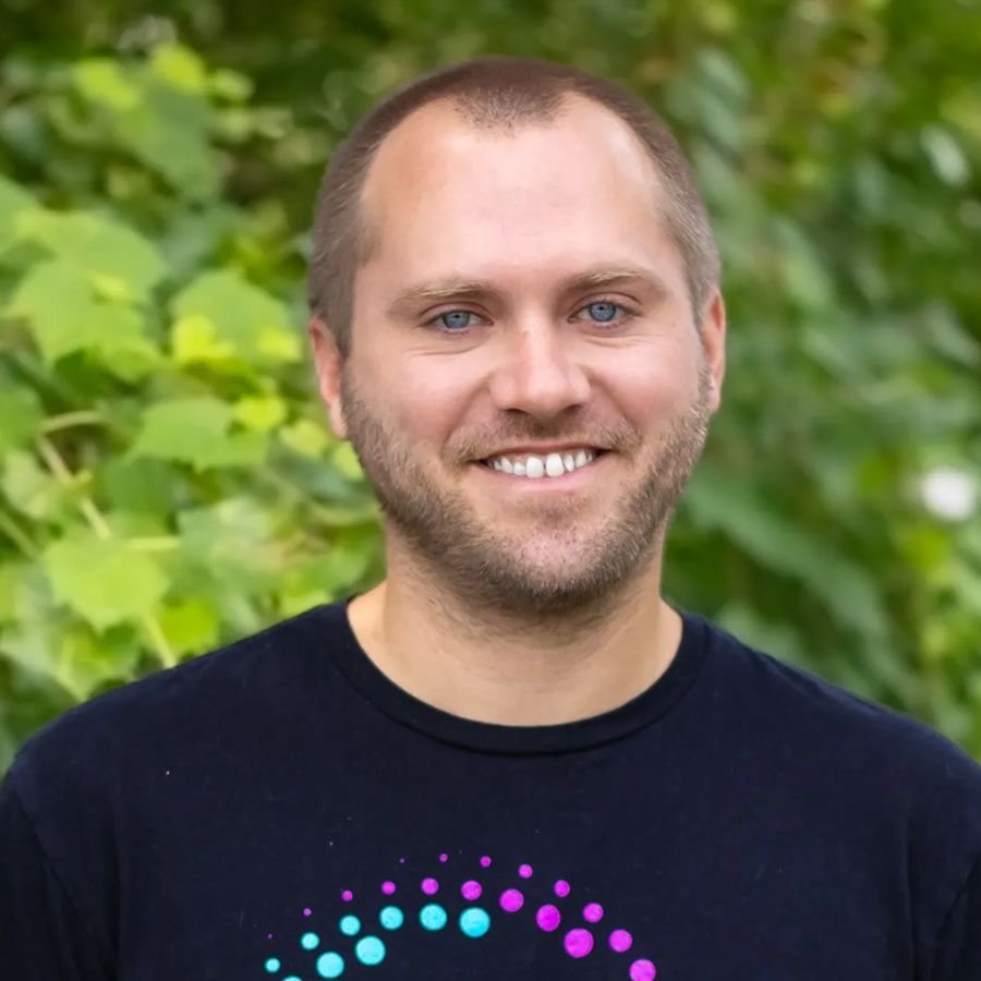 Man smiling, wearing a black shirt with 