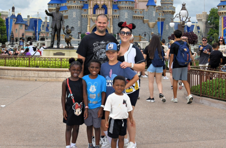 Family posing in front of Cinderella Castle at Disney World.