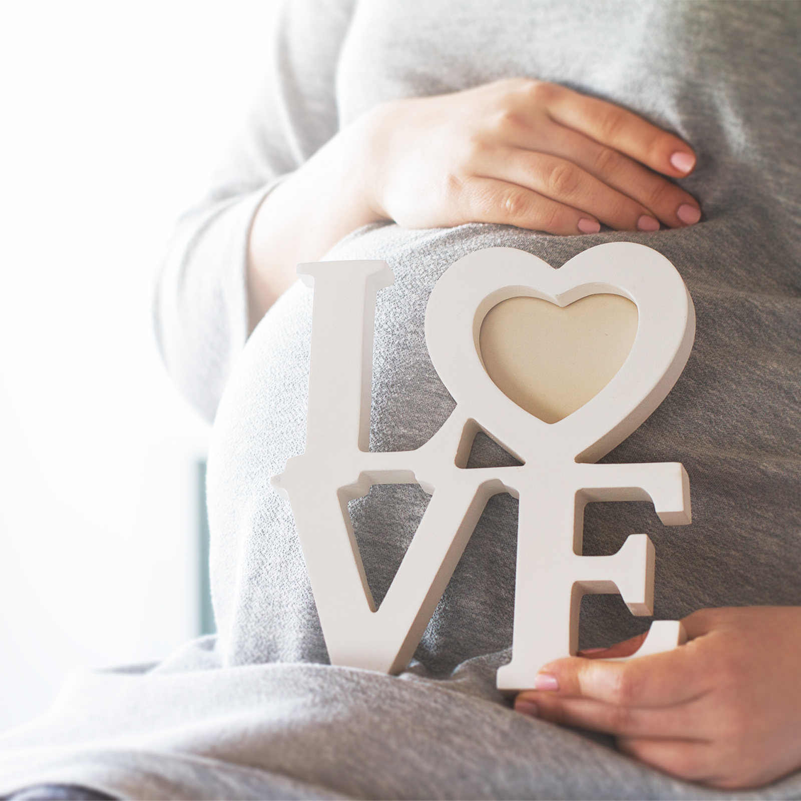 Pregnant person holding a white 