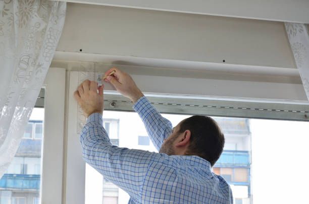 Close-up of white venetian window blinds with sunlight reflecting off horizontal slats