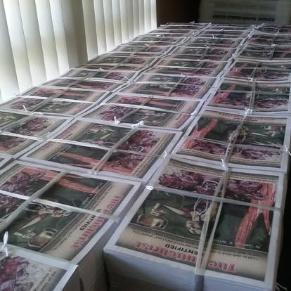 A bunch of newspapers are stacked on top of each other