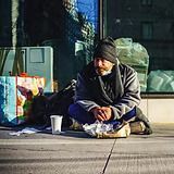homeless man sitting on the street