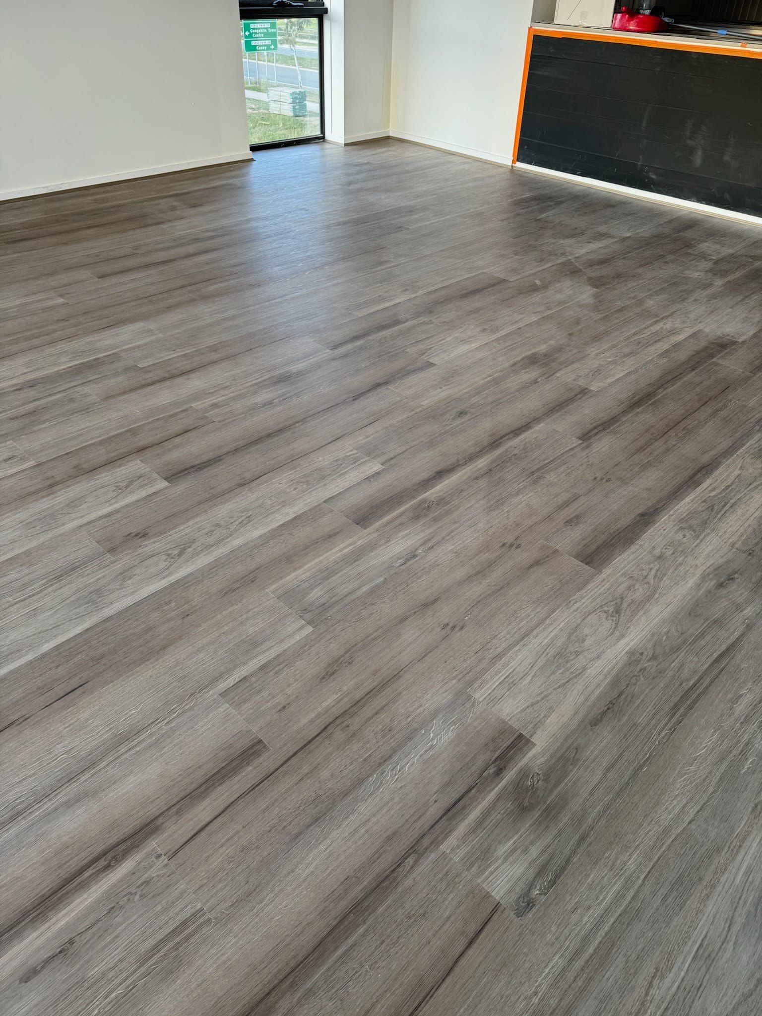 A living room with a wooden floor and a window.
