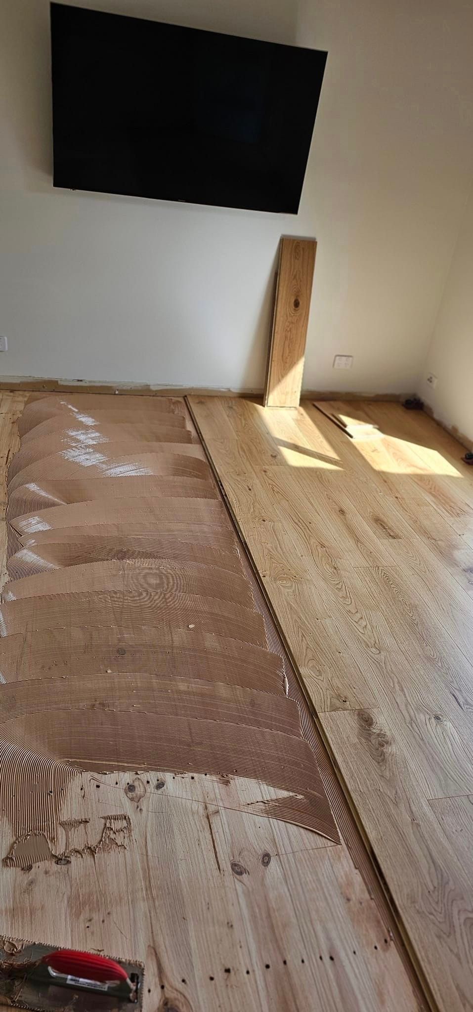 A living room with a wooden floor and a flat screen tv.