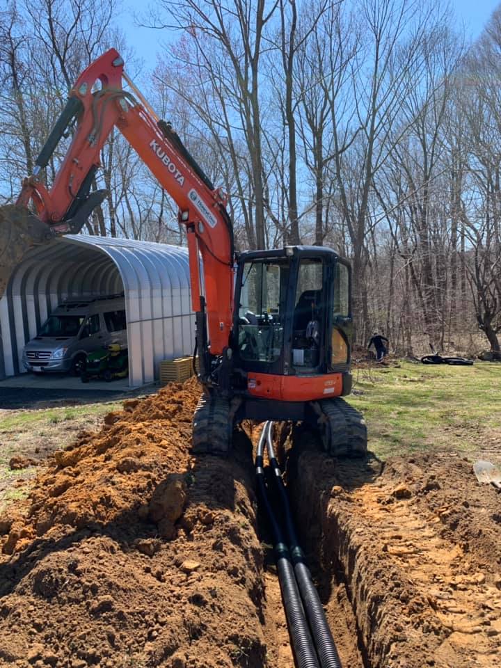 ditch digger at work to expand downspout