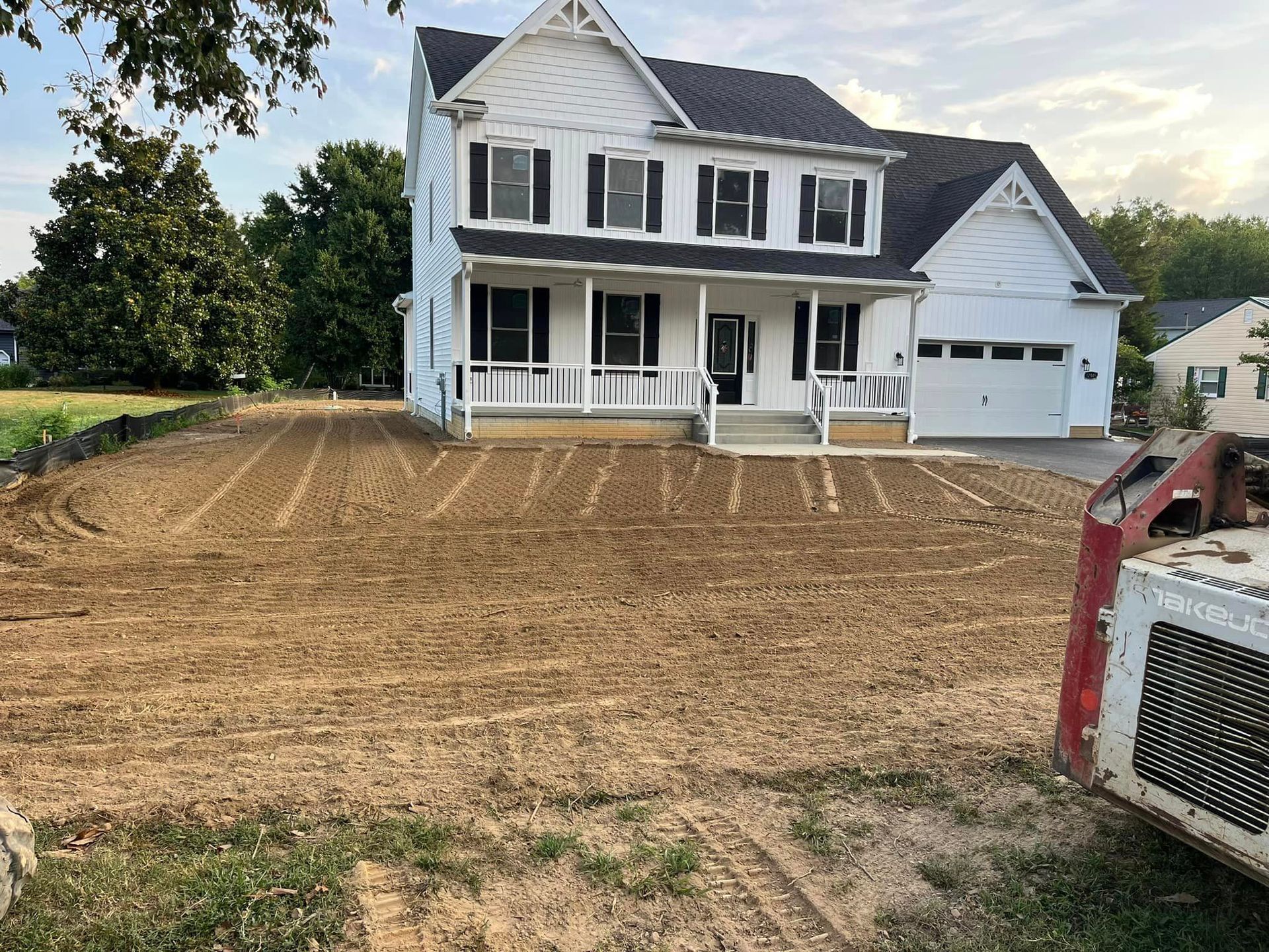 tree removal with red equipment in front of house
