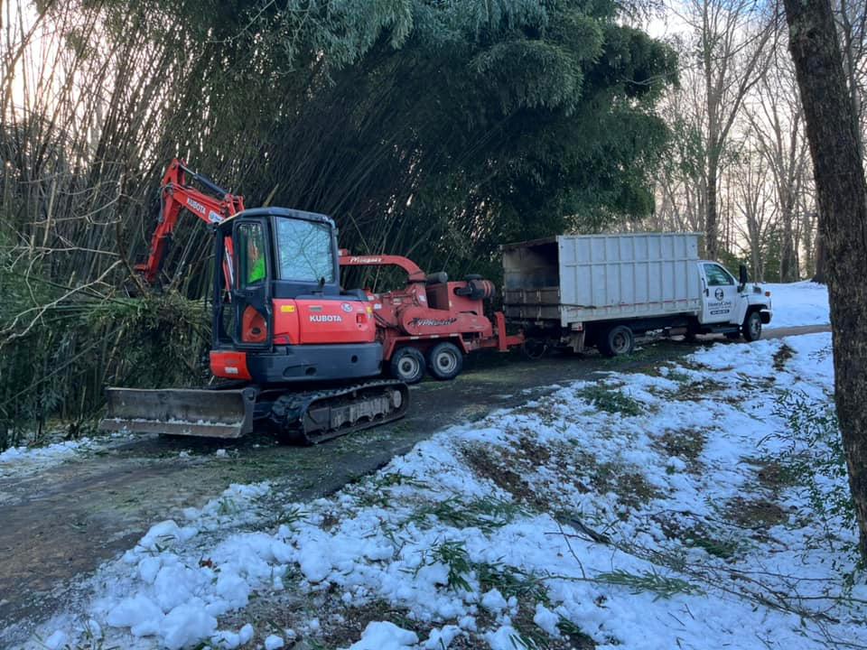 A red excavator is parked next to a white truck.