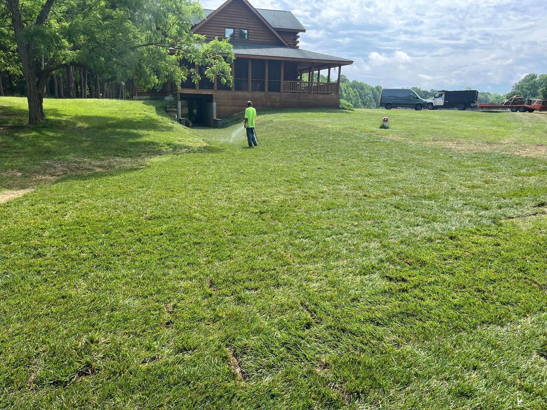 man watering sod after installation