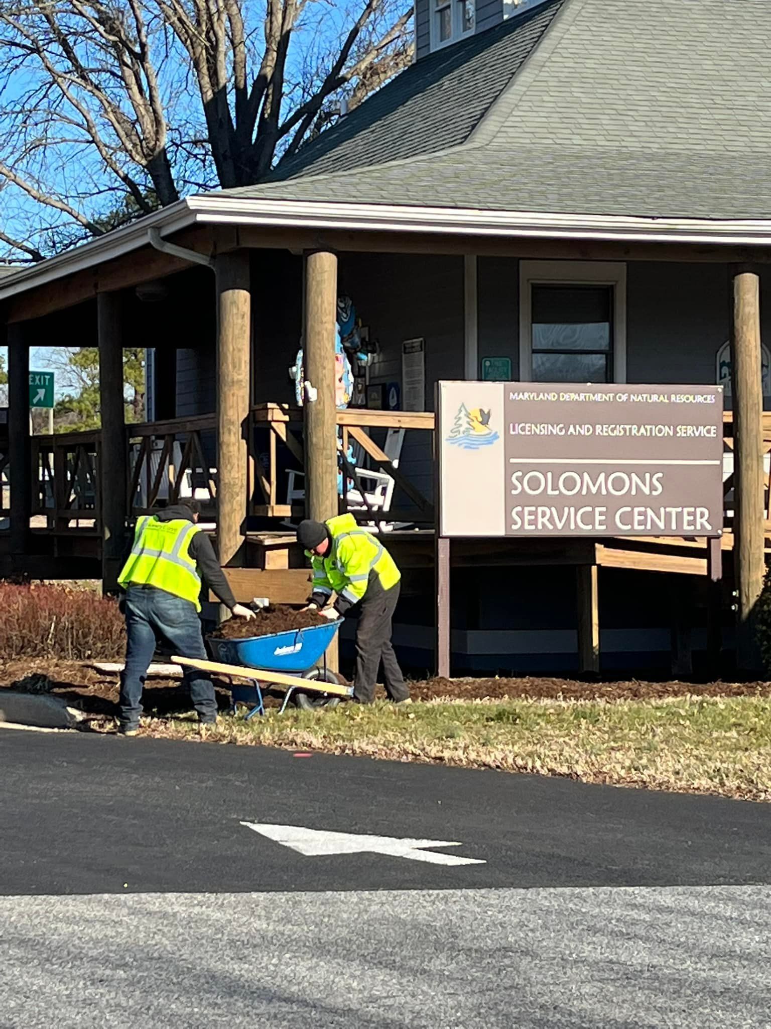 A couple of men are standing in front of a building with a sign that says Solomon 's Service Center.