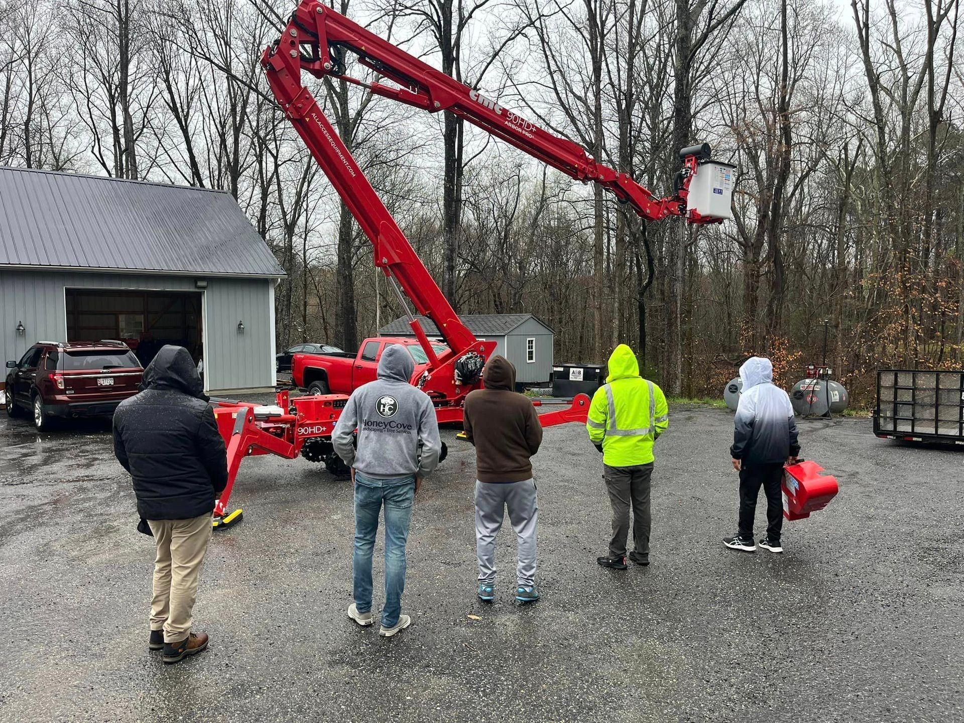 A group of people are standing in front of a crane in a parking lot.
