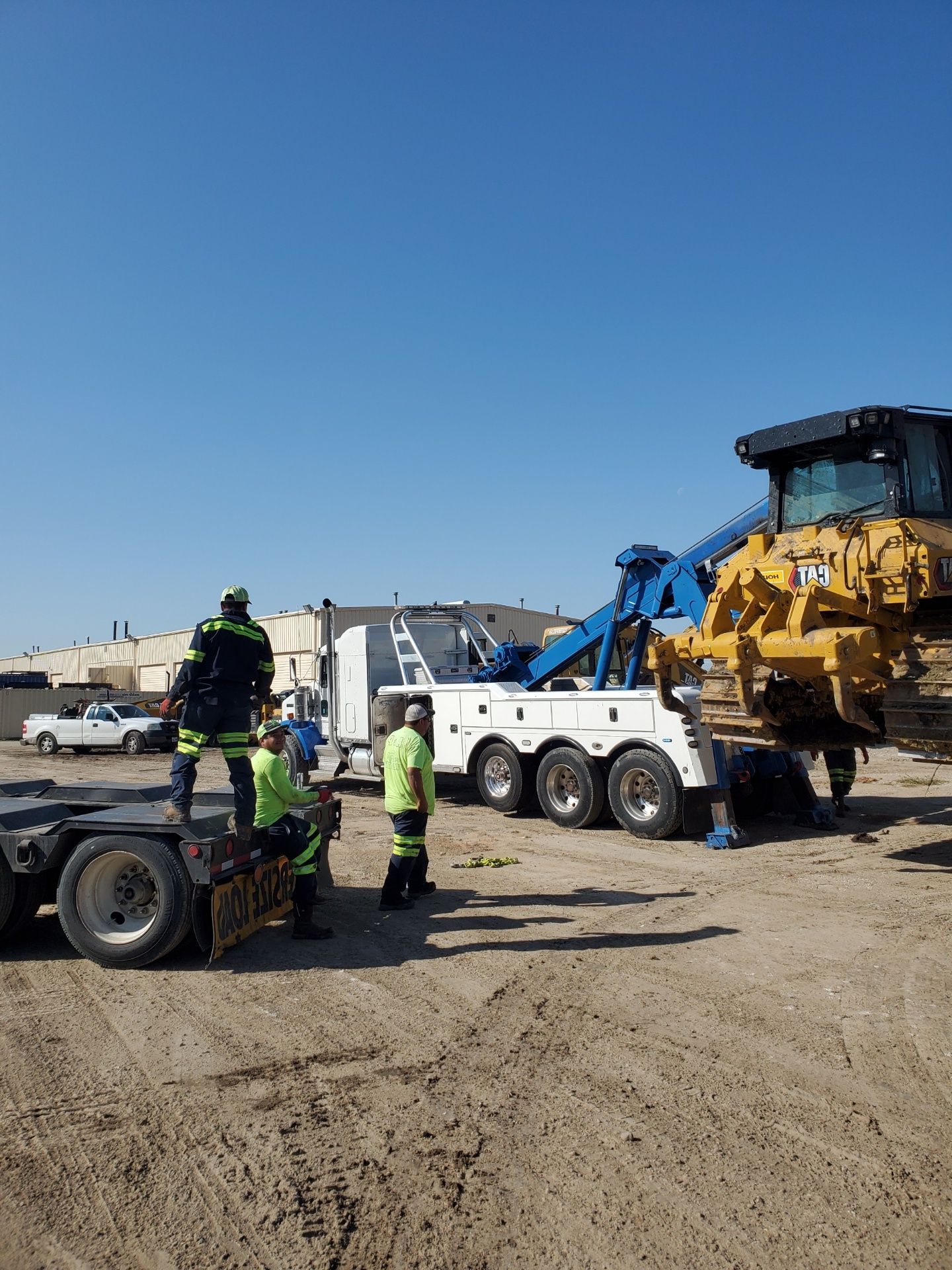 A group of excavation vehicles parked in a dirt lot in Leander, TX.