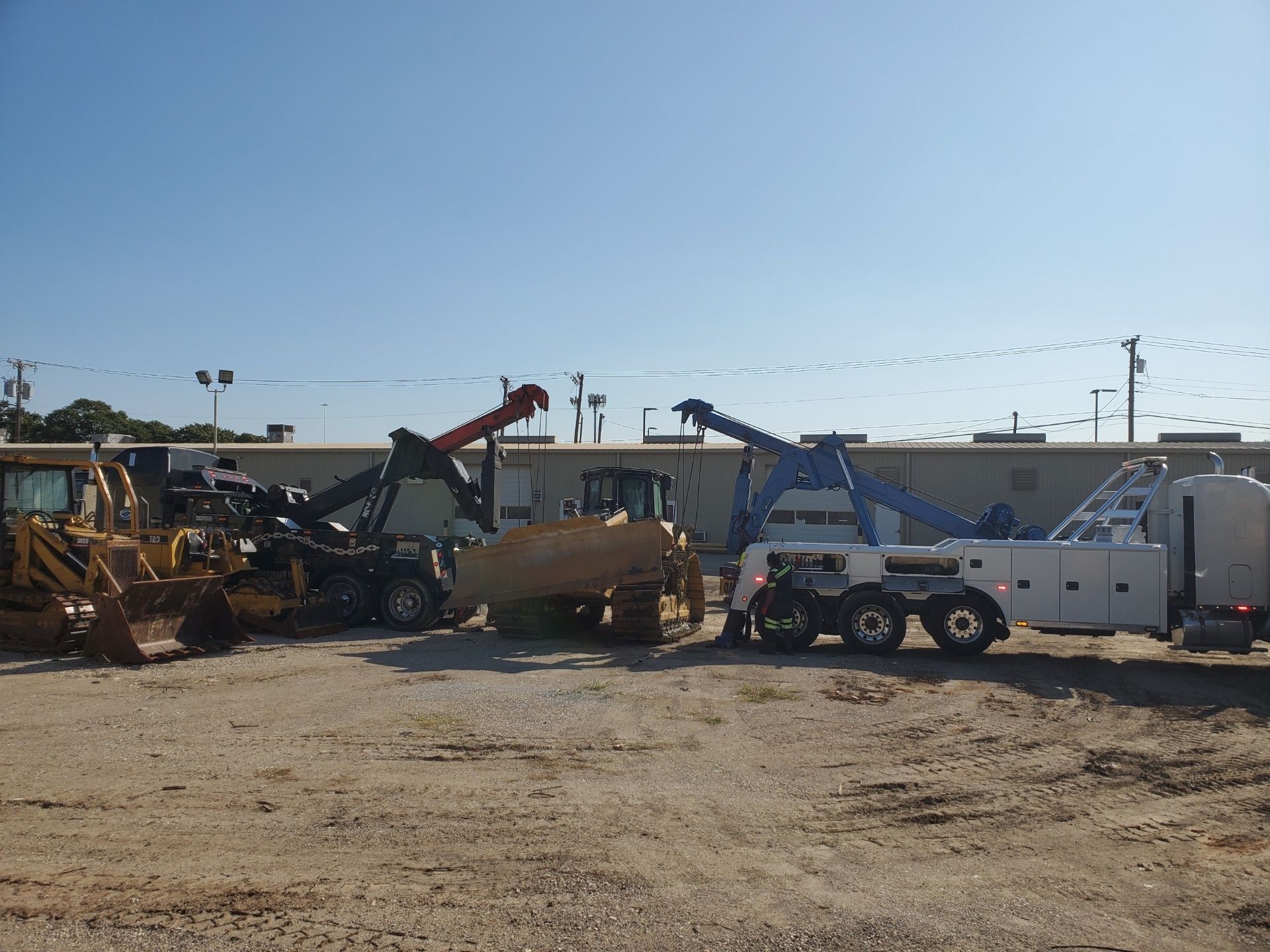 Two bulldozers are parked next to each other in a dirt field.
