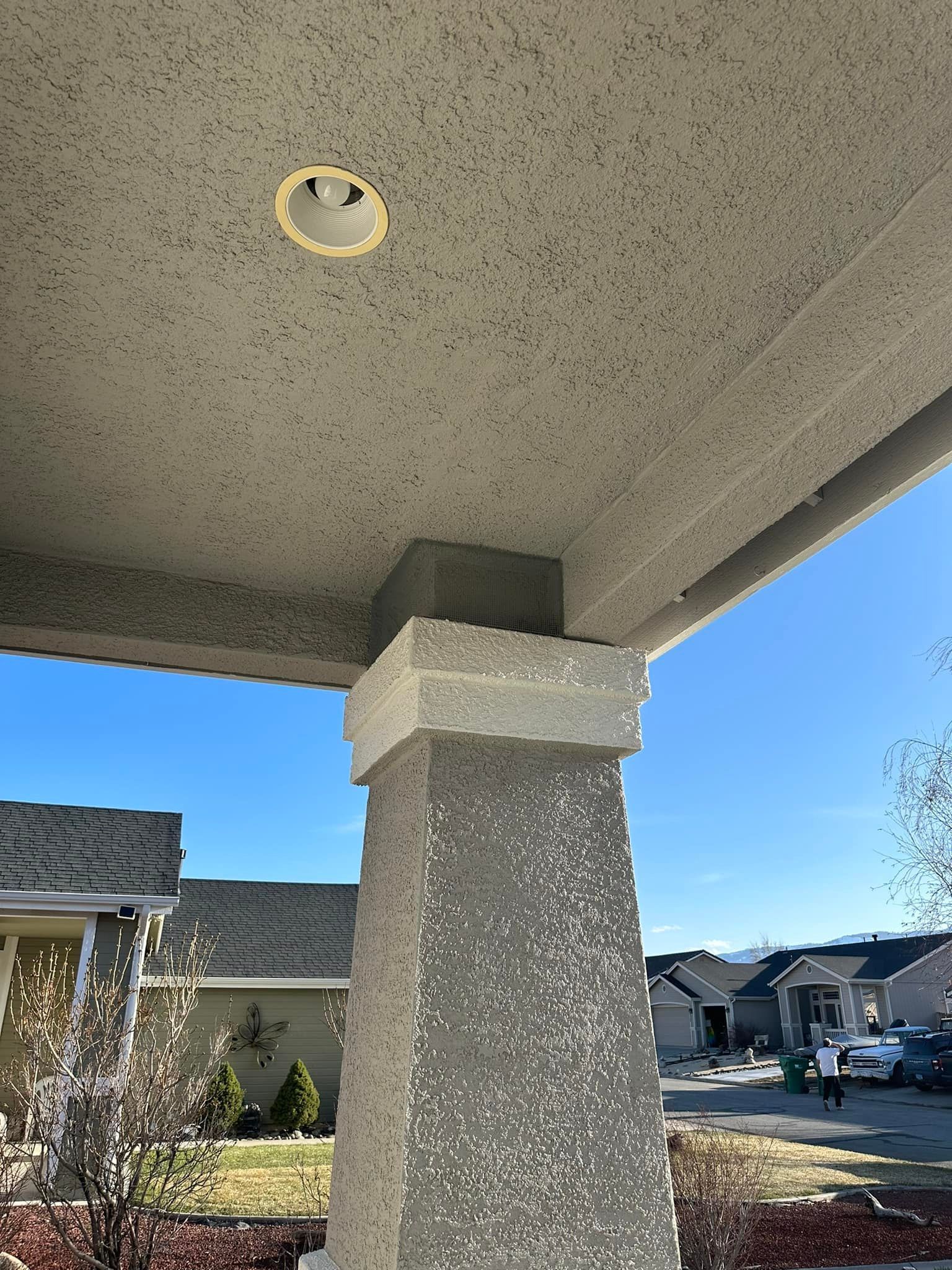 A ceiling light is hanging from the ceiling of a porch.