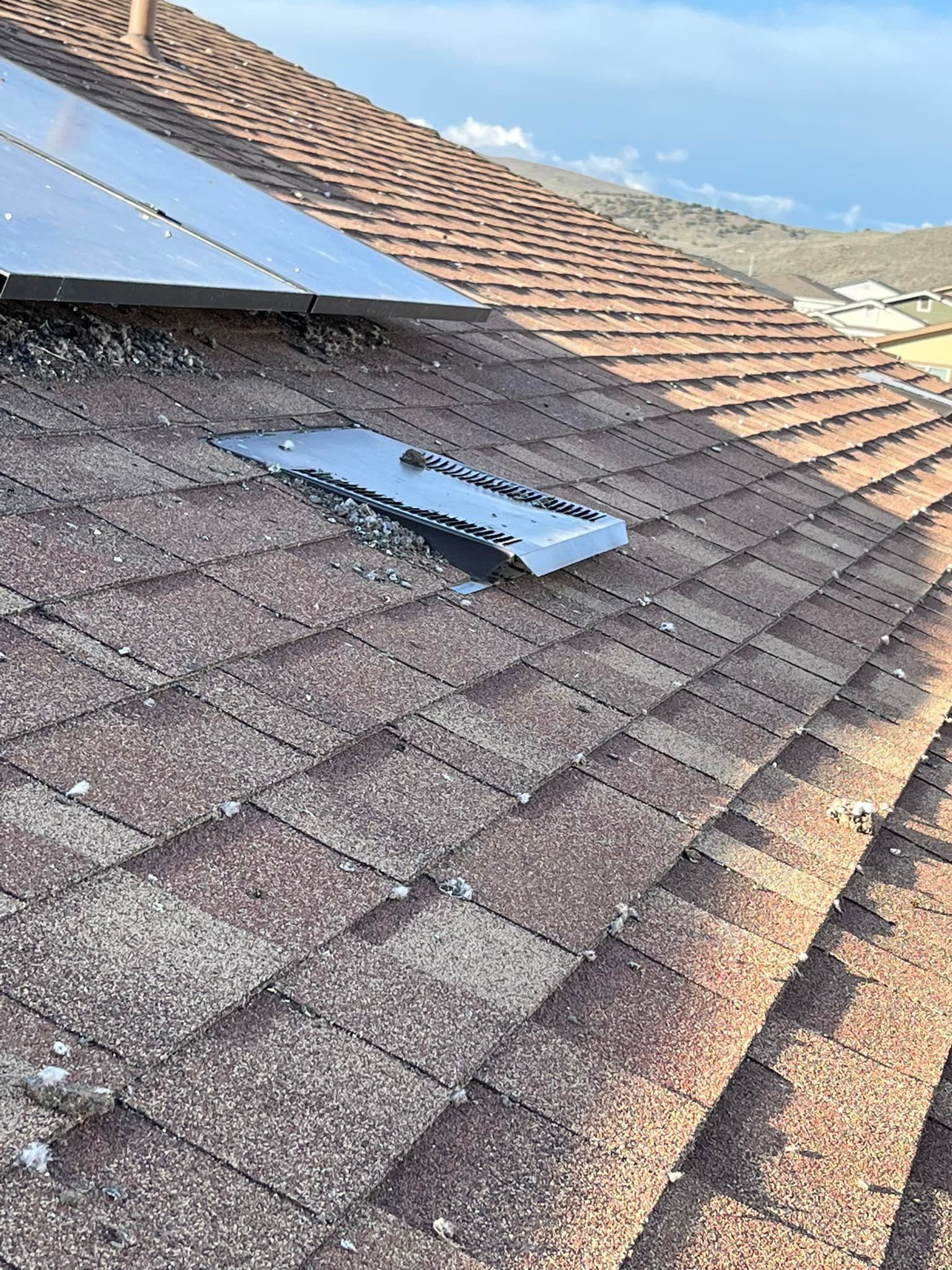 A roof with a hole in it and a solar panel on it.