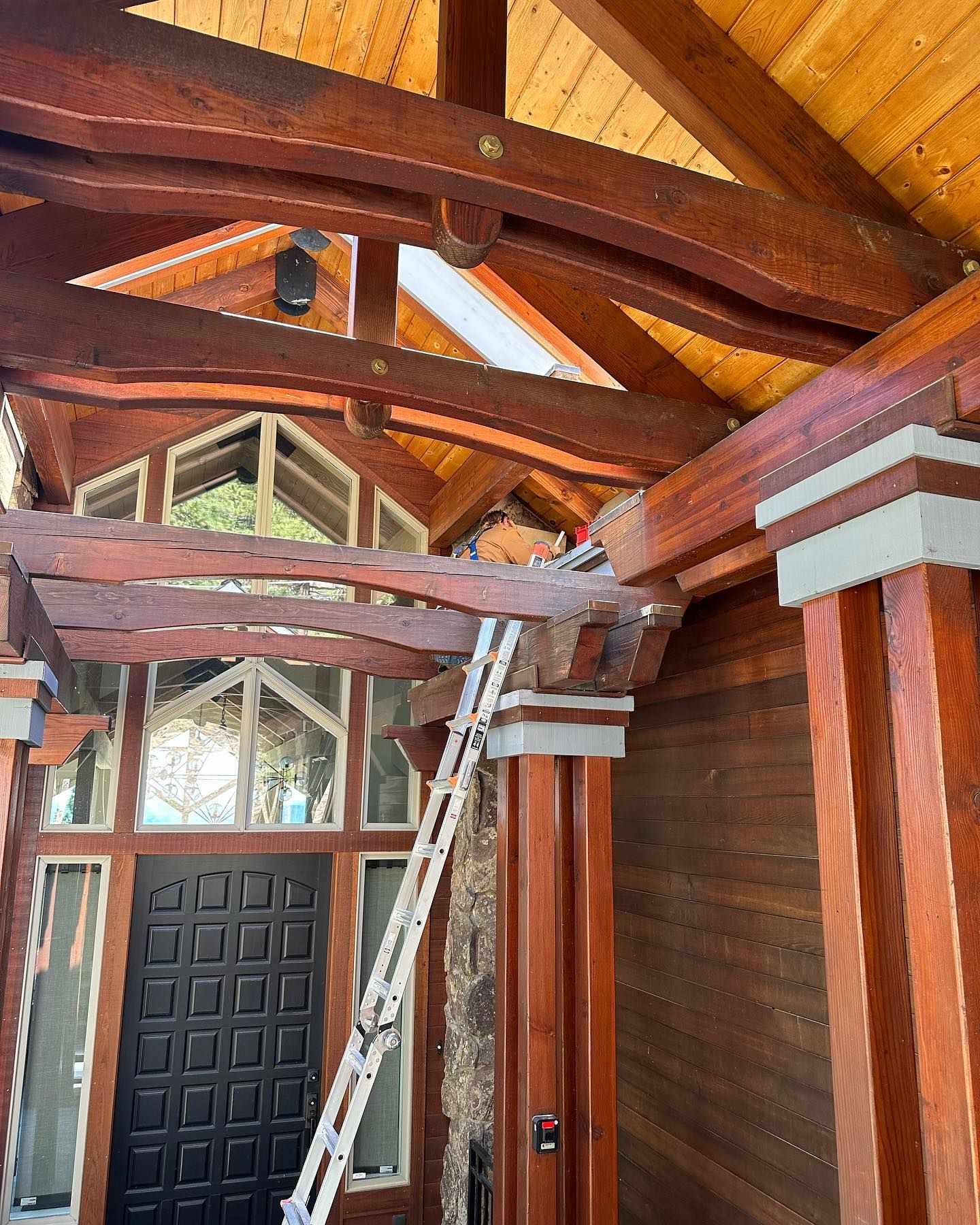 A ladder is hanging from the ceiling of a wooden house.