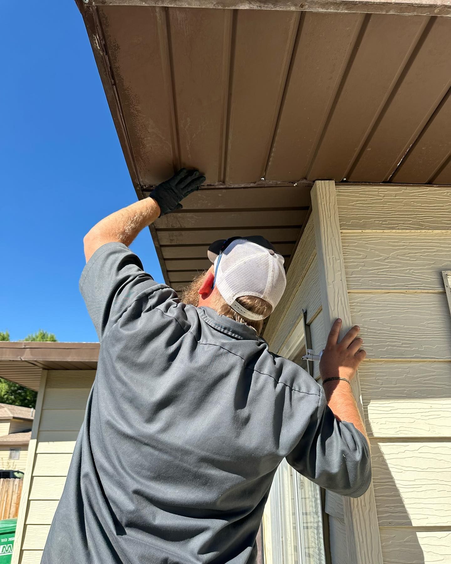 A man is working on the roof of a house.
