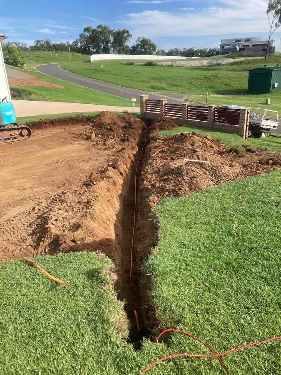 A Large Hole In The Ground In The Middle Of A Lush Green Field — AA Electrical Co in Yeppoon, QLD