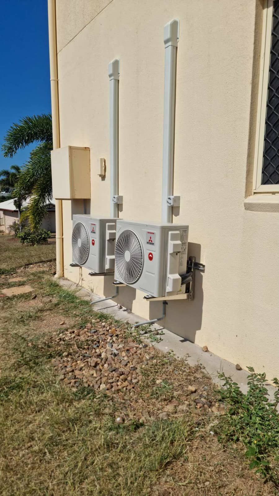 Two Air Conditioners Are Installed On The Side Of A Building — AA Electrical Co in Yeppoon, QLD