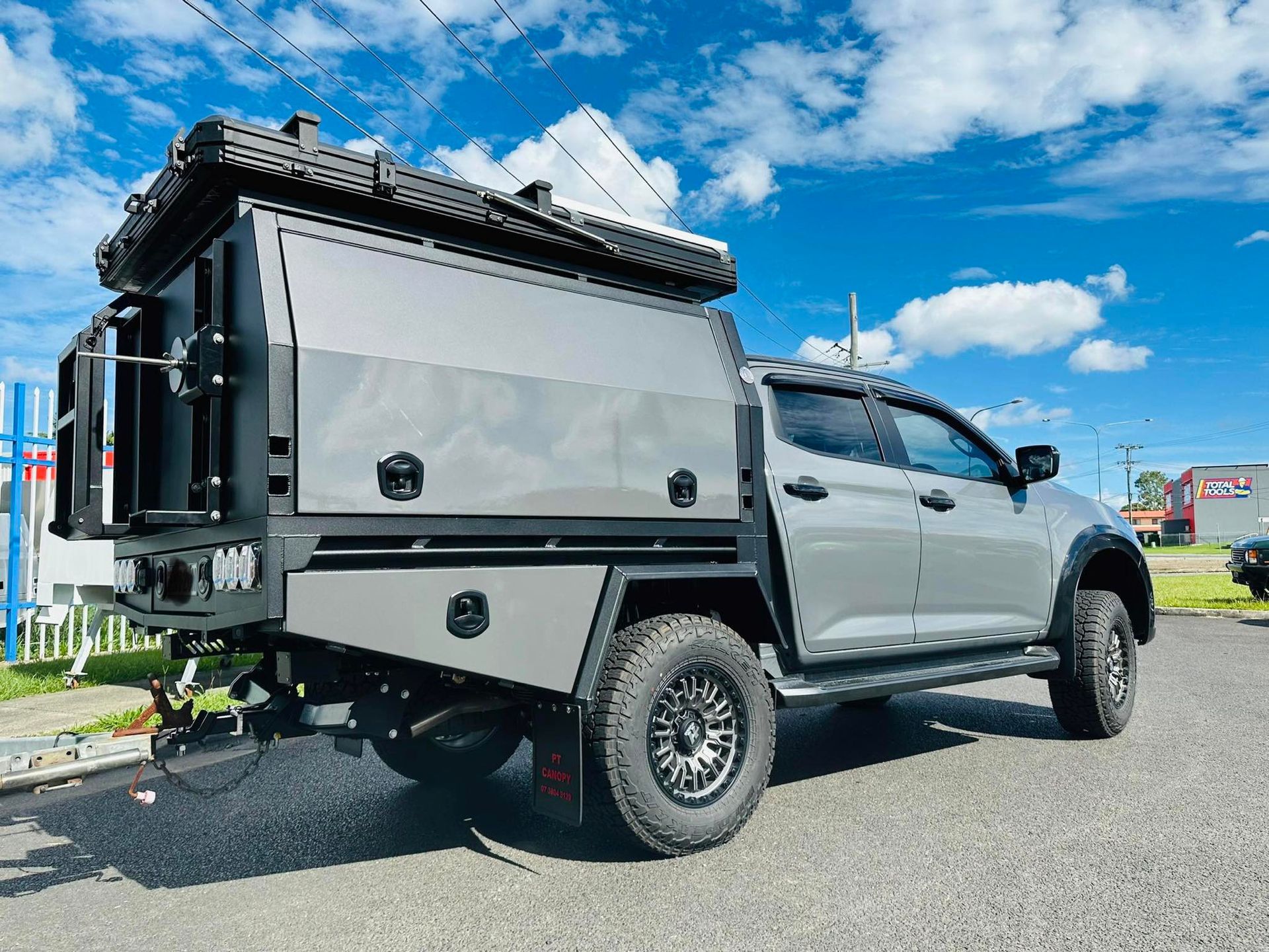 Utility Truck With a Custom Camper Shell, Roof Rack, and Off-Road Tires Parked Outside  — PT Canopy In Slacks Creek, QLD