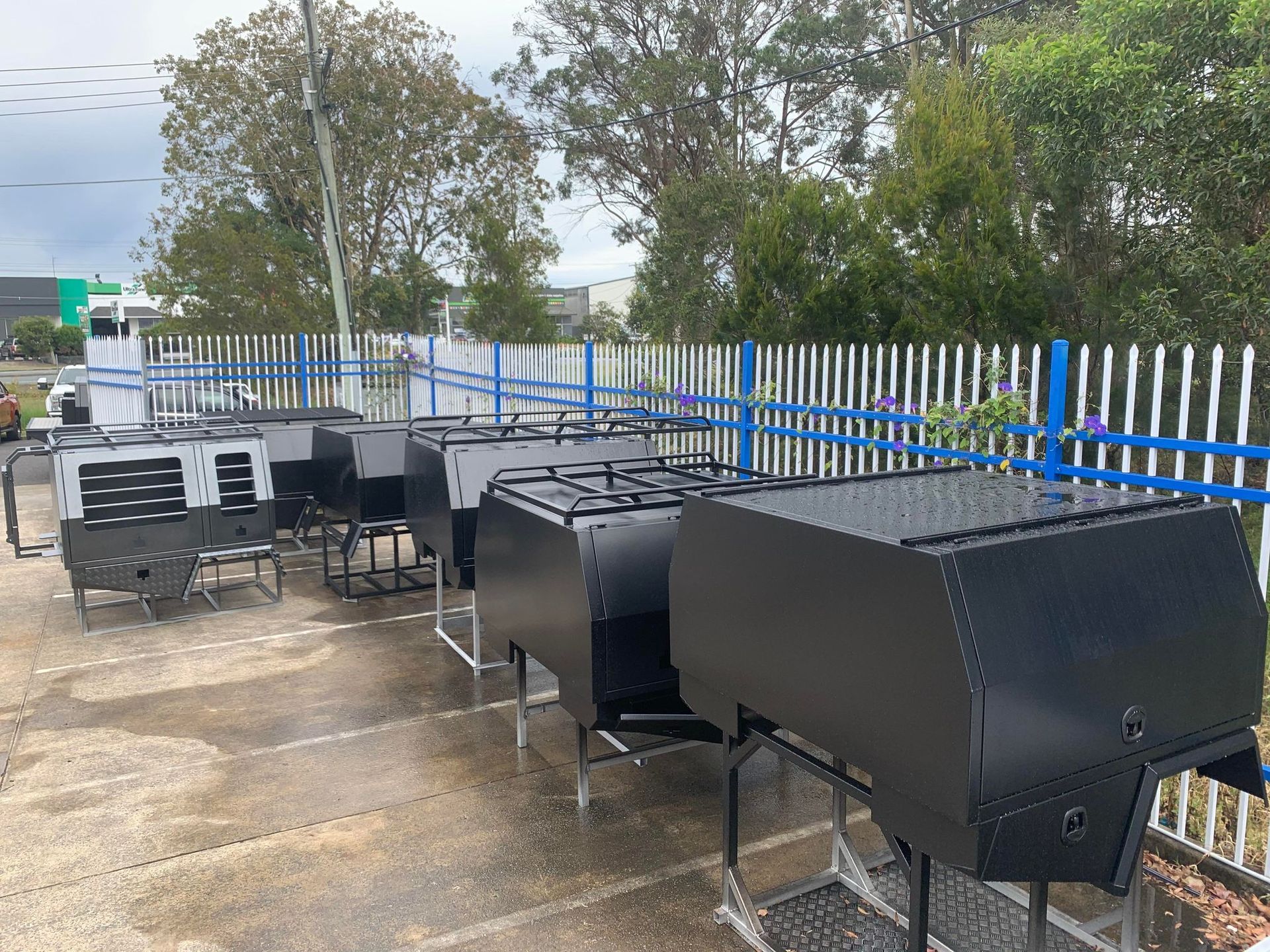 Several Black Truck Bodies on Stands In a Row Outdoors — PT Canopy In Slacks Creek, QLD