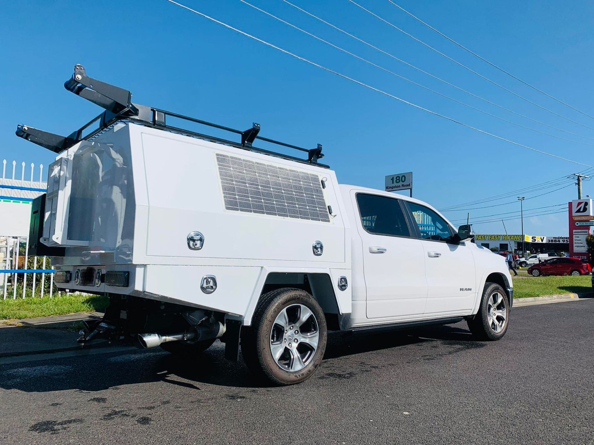 White Utility Truck With a Bed and Rack, Parked on Pavement Under a Blue Sky — PT Canopy In Slacks Creek, QLD
