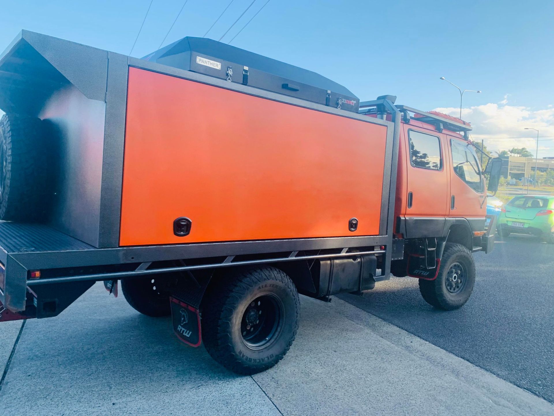 Orange and Black Off-road  Has a Large Storage Box, Black Wheels, and a Roof Rack — PT Canopy In Slacks Creek, QLD